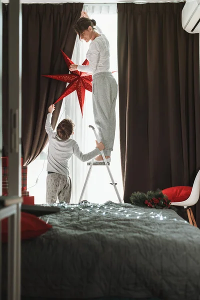 Mother Son Decorating Home Window Christmas Red Star Magic Winter — Stock Photo, Image