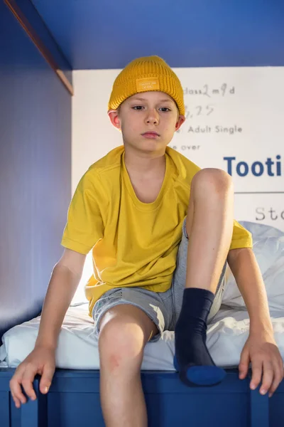 Chłopiec Żółtej Koszulce Kapeluszu Spędza Czas Siedząc Niebieskim Dwupoziomowym Łóżku — Zdjęcie stockowe