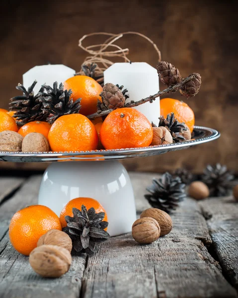 Composición de vacaciones con mandarinas, conos de pino, nueces en madera —  Fotos de Stock