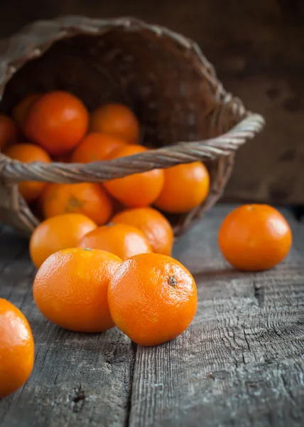 Basket and Tangerines on Wooden Background