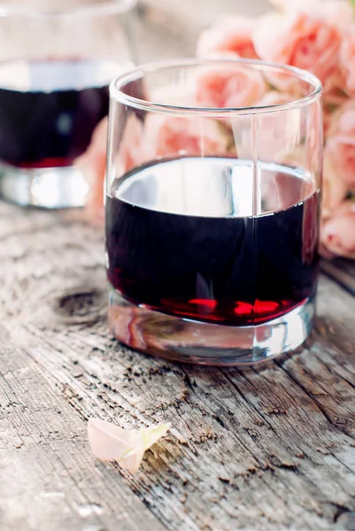 Ποτήρι κόκκινο κρασί και ροζ τριαντάφυλλα — Φωτογραφία Αρχείου
