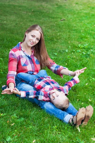 Lycklig mor leker med son i parken — Stockfoto
