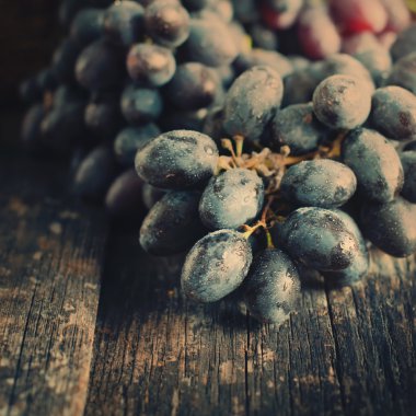 Ahşap arka plan üzerinde küme mavi üzüm. Tonda