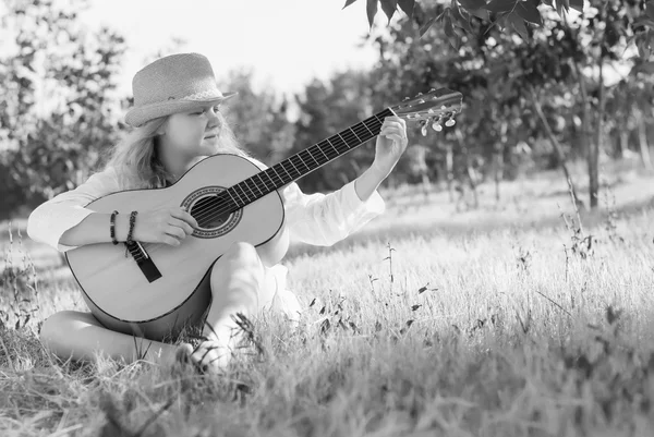 Hippie-Mädchen mit Hut spielt auf der Gitarre. Straffung — Stockfoto