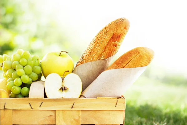 Picknickmand met vers voedsel, brood en Fruit — Stockfoto