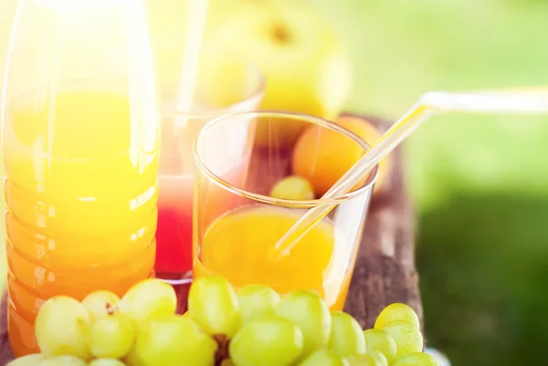 Стакан свежего сока и фруктов на деревянном столе — стоковое фото