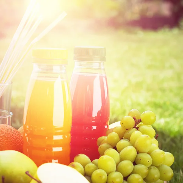 Deux bouteilles de jus et de fruits frais — Photo