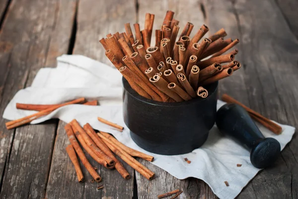 Cinnamon Sticks in a Stone Mortar on Wooden Country Background — Stock Photo, Image