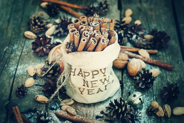 Cinnamon in Bag with Embroidery Happy New Year and  other christmas ingredients. Toned — стокове фото