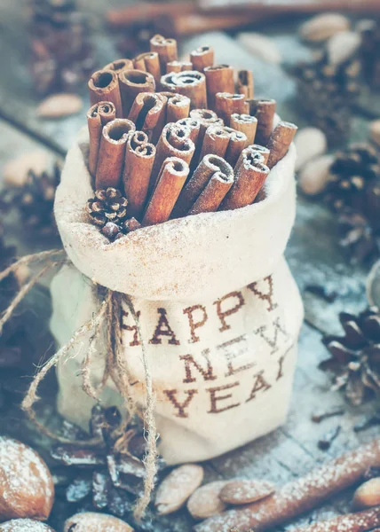 Bastoncini di cannella in una borsa di lino Ricamato con felice anno nuovo — Foto Stock