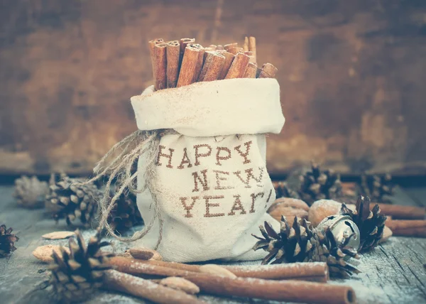 Canela em um saco de linho com bordado Feliz Ano Novo e outros ingredientes de Natal Fotos De Bancos De Imagens