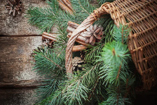 Branches of Blue Fir Tree, Cinnamon and Pine Cones Scattered from Rural Basket. Top view — Stock Photo, Image