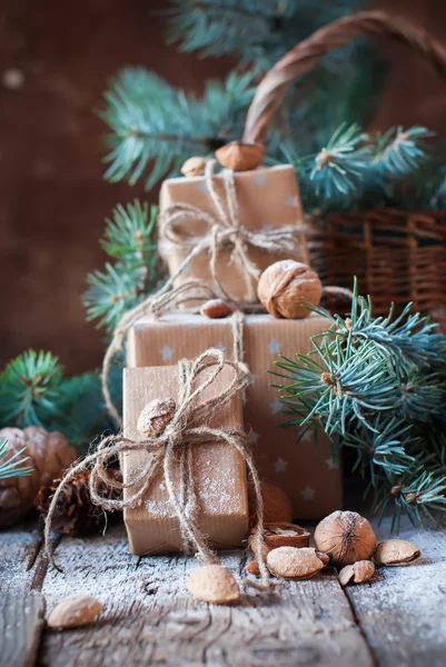 Cajas de Navidad, Coníferas, Conos de Pino, Abeto, Cesta, Nueces, Almendras sobre Fondo de Madera. Regalos en estilo Vintage —  Fotos de Stock