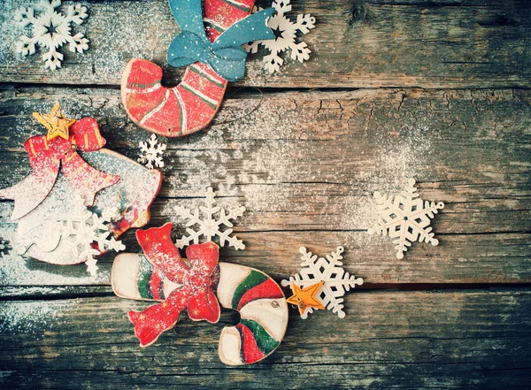 Imagen tonificada con abeto juguetes dulces bastones, campana y copos de nieve sobre fondo de madera — Foto de Stock
