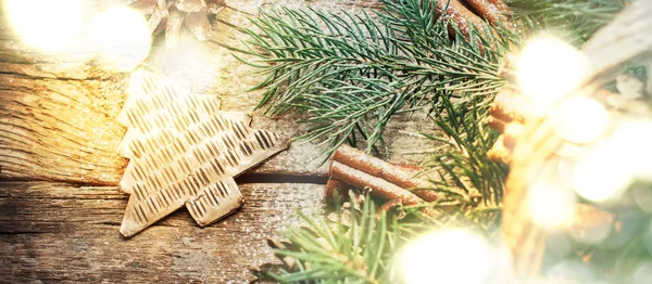 Giocattolo dell'abete del metallo di Natale dell'annata, coni di pino, cannella, rami di conifere sulla tavola di legno — Foto Stock