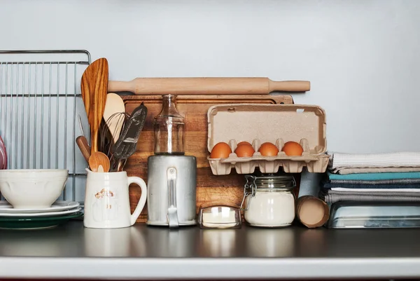 Edények, étkészlet és termékek állni a konyhaasztalon — Stock Fotó