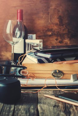 Men's Stuff with Different Accessories on wooden table. Books, daily logs, wine, box and earphones, gadget