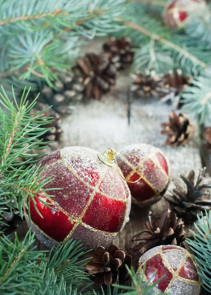 Weihnachtskomposition mit roten Kugeln, Tannenzapfen, Tanne auf Holzgrund — Stockfoto