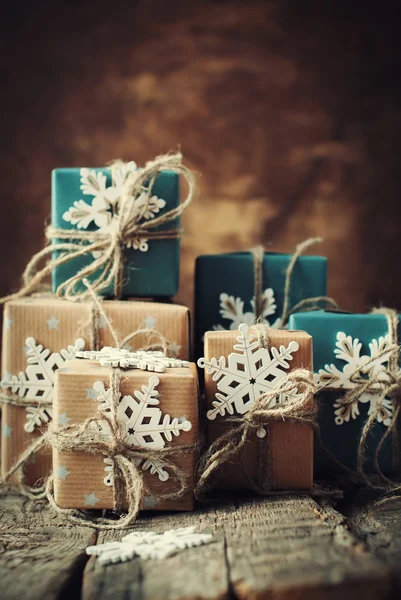 Cajas festivas decoradas en beige, papel azul, cordón de lino y copos de nieve sobre mesa de madera. Tonificado — Foto de Stock