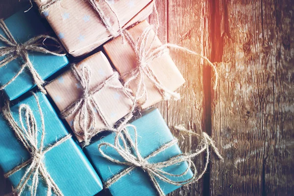 Festive Boxes are Packed into a Brown Paper with Linen Cord on Wooden Table