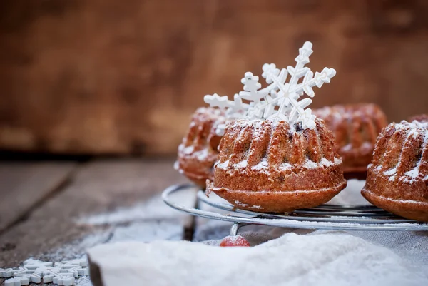 Маленький выпеченный торт, украшенный белыми снежинками и сахаром для глажения — стоковое фото