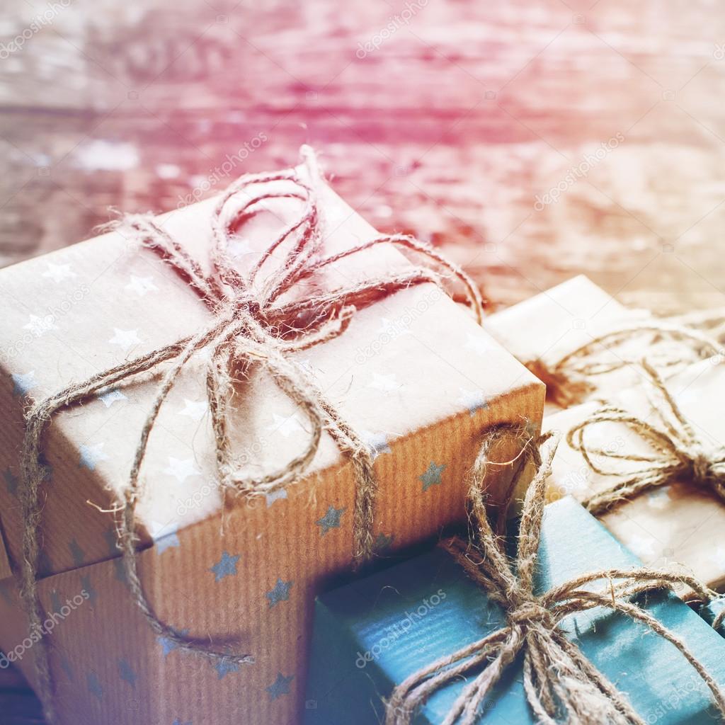 Festive Boxes in a Brown Paper with Linen Cord on Wooden Background
