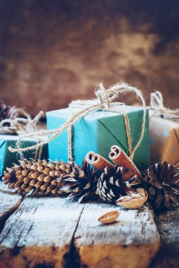 Keten kablosu, tarçın, çam kozalakları, ahşap arka plan üzerinde fındık ile Noel hediyeleri