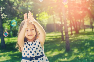 Güneşli bir gün kabarcıkları ile mutlu güzel kız. Güneş ışığı etkisi