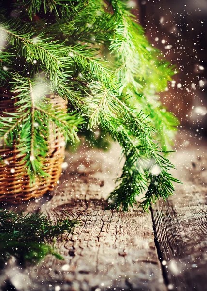 Green Branches of Fir Tree on wooden table. Drawn Snowfall — Stock Photo, Image