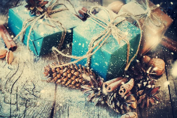Festliche Geschenke mit Leinenkordel, Tannenzapfen, Nüssen. Schnee gezogen — Stockfoto