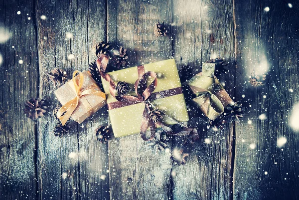 Cajas festivas con cinta marrón sobre mesa de madera. Nieve dibujada — Foto de Stock