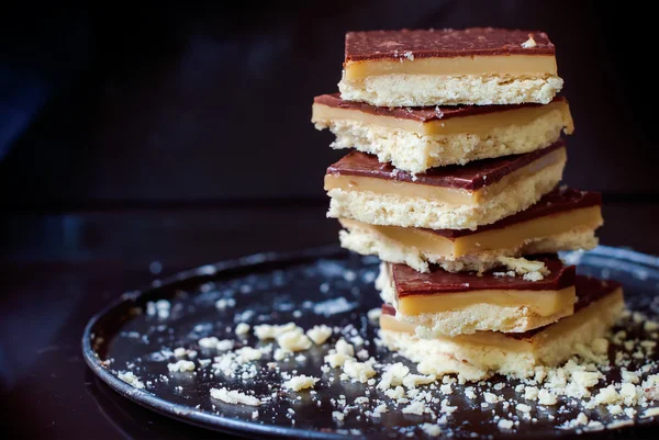 Pila de galletas de chocolate con caramelo en bandeja negra —  Fotos de Stock