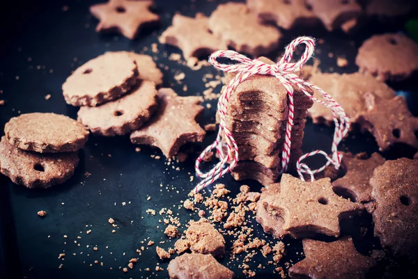 Biscotti di cioccolato di Natale a forma di stella sulla tavola nera — Foto Stock