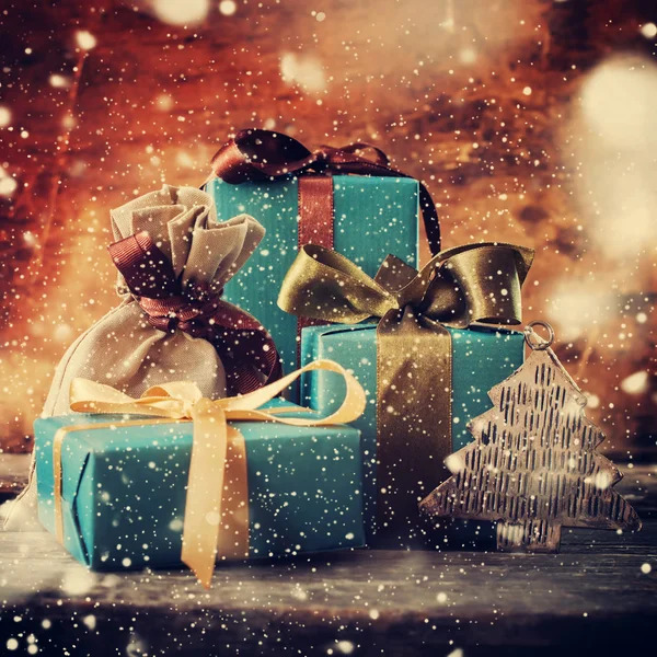 Weihnachtsgeschenke mit farbigen Schleifen. Schneefall. Jahrgang — Stockfoto