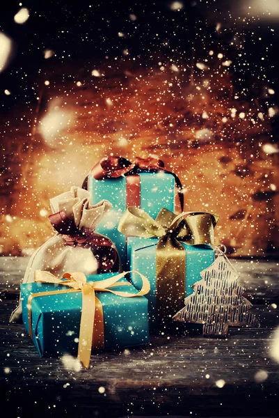 Regalos de Navidad y juguete de abeto bajo la nevada. Cajas festivas sobre fondo de madera —  Fotos de Stock