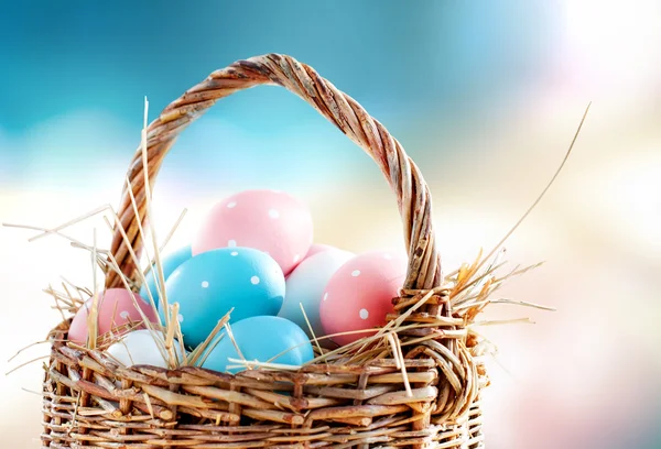 Cestino uova di Pasqua dipinto rosa piselli blu sfondo colorato — Foto Stock