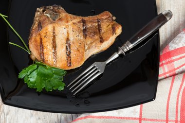 siyah bir tabak kızarmış domuz pirzolası