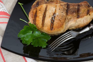 siyah bir tabak kızarmış domuz pirzolası