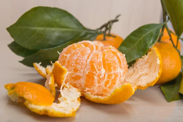 Mandarine oder Mandarine mit Blättern und Zweigen auf einem Marmortisch — Stockfoto