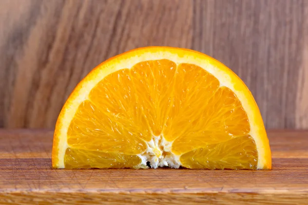 Slice of orange on a wooden table — Stock Photo, Image