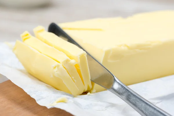 Świeżego masła w formie i nóż — Zdjęcie stockowe