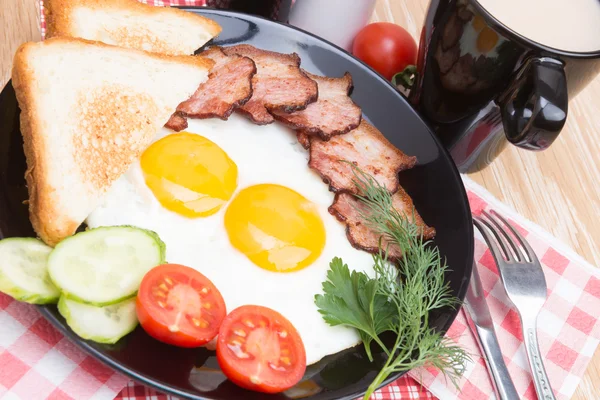 fried eggs with bacon on black dish