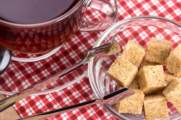 Brauner Rohrzucker und eine Tasse Tee — Stockfoto