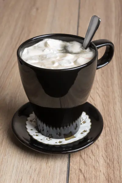 Coffee with marshmallows in a black mug — Stockfoto