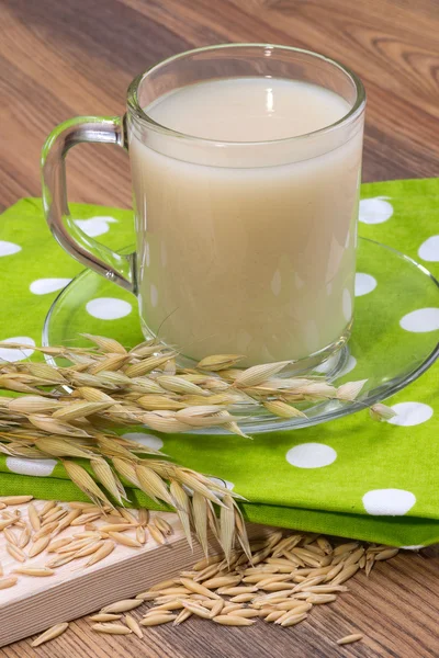 Oat decoction in a transparent mug, grains and ears — Stock Photo, Image