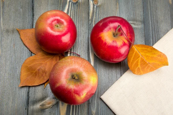 Зимние красные яблоки на деревянном столе — стоковое фото