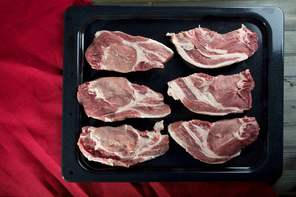 Chunks of fresh pork meat on a baking sheet — Stock Photo, Image