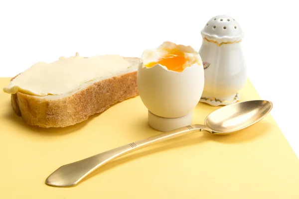 Gekookt ei, brood met boter, zout kelder en koperen lepel — Stockfoto