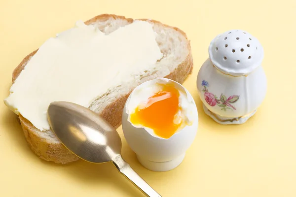 Gekochtes Ei, Brot mit Butter, Salzkeller und Messinglöffel — Stockfoto