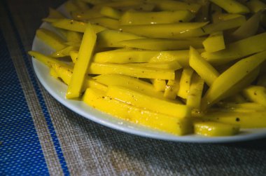 Patates kızartması, beyaz tabakta patates cipsi. Üst Manzara. Mikrodalga fırında pişirilmiş.